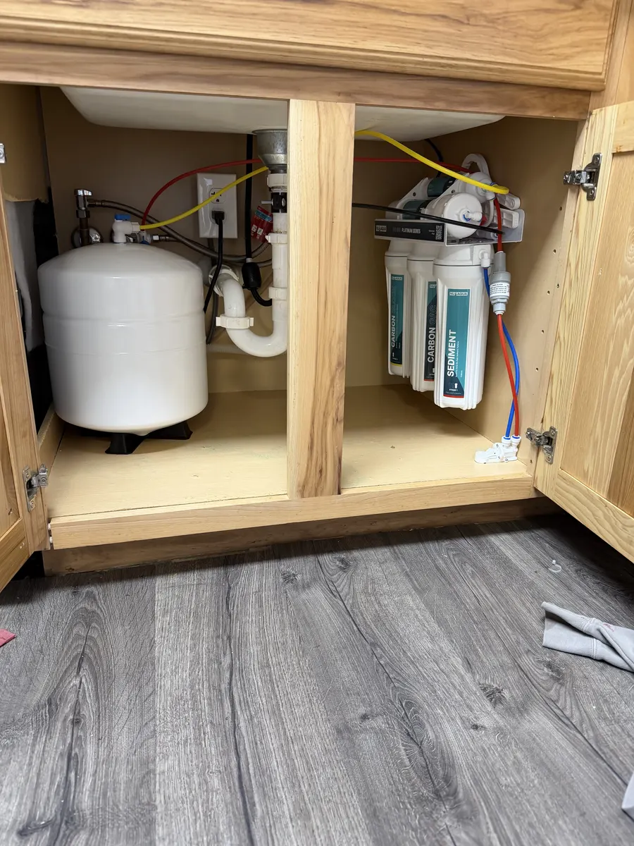 Drinking water filtration system and storage tank installed beneath a kitchen sink