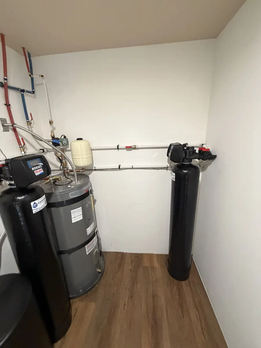 Black water filtration tanks and plumbing installed in a home utility room